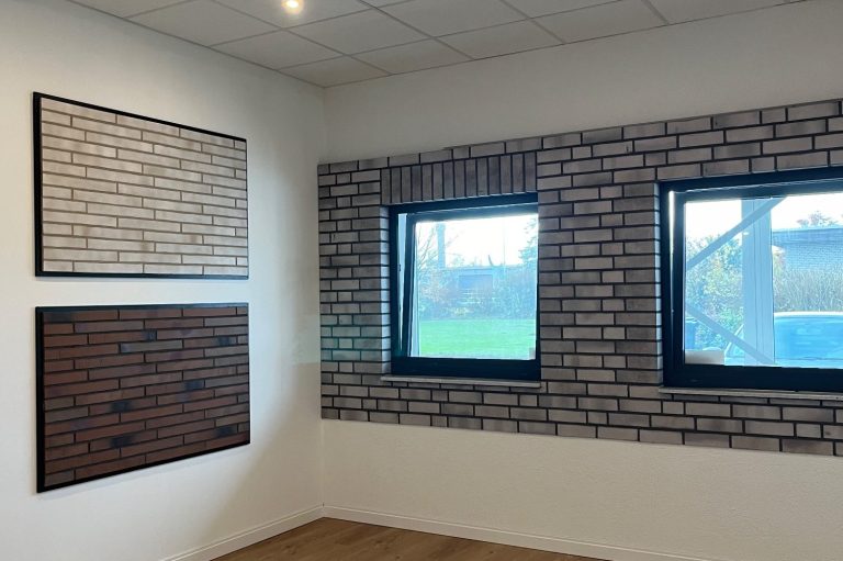 Wand mit zwei Fenstern und verschiedenen Mauerwerktexturen in neutralen Farben.